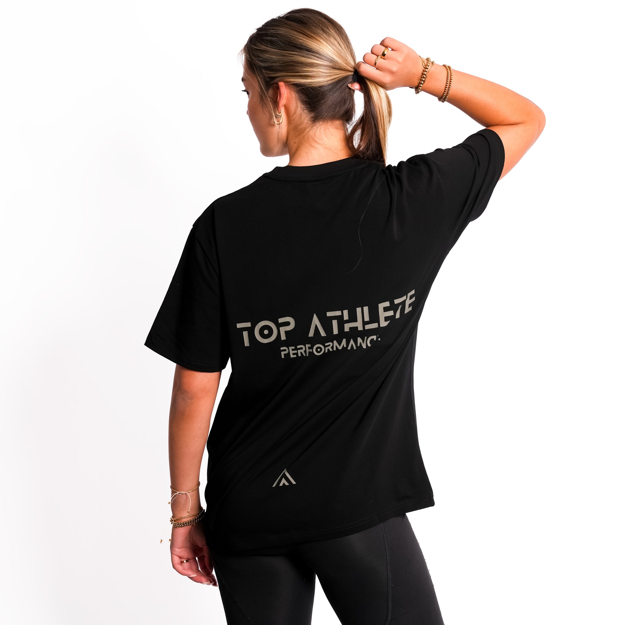 Back view of woman wearing black colour Top Athlete unisex oversized activewear t-shirt.