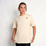 woman wearing a beige top athlete performance tee