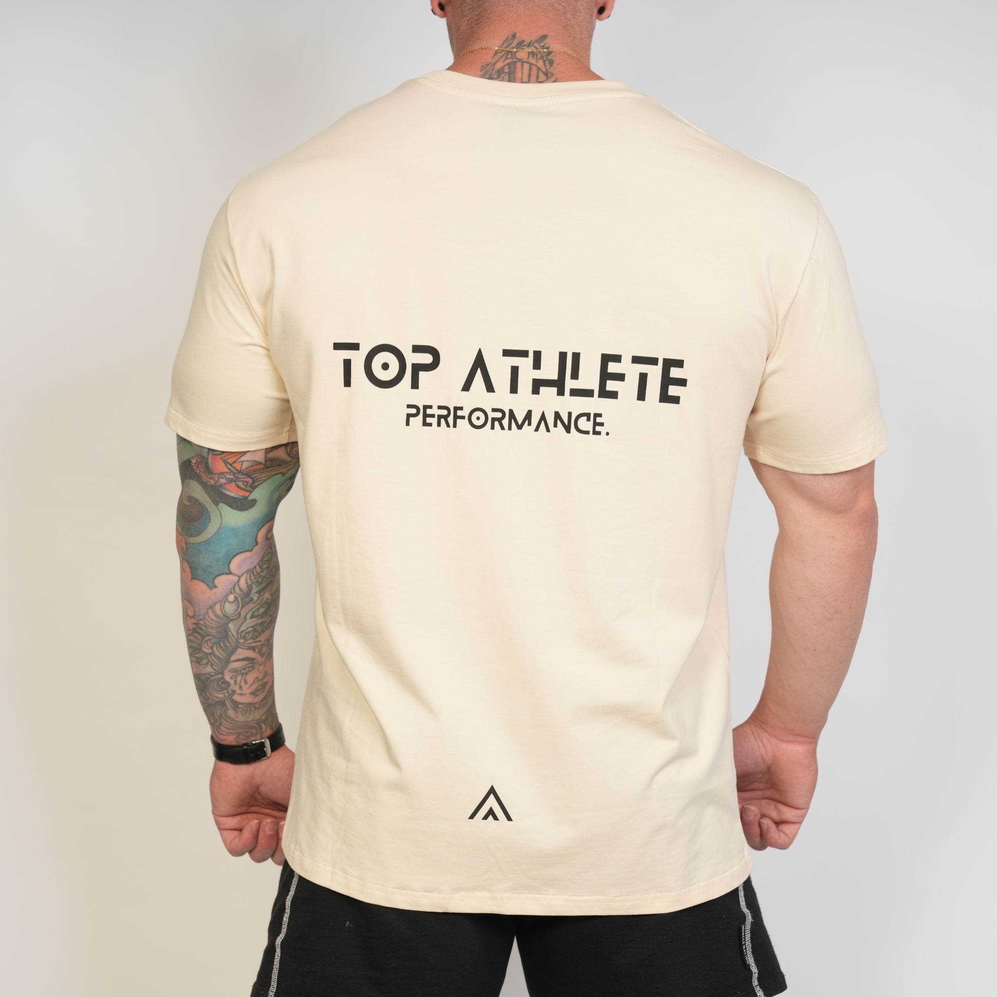Man wearing a beige top athlete performance tee