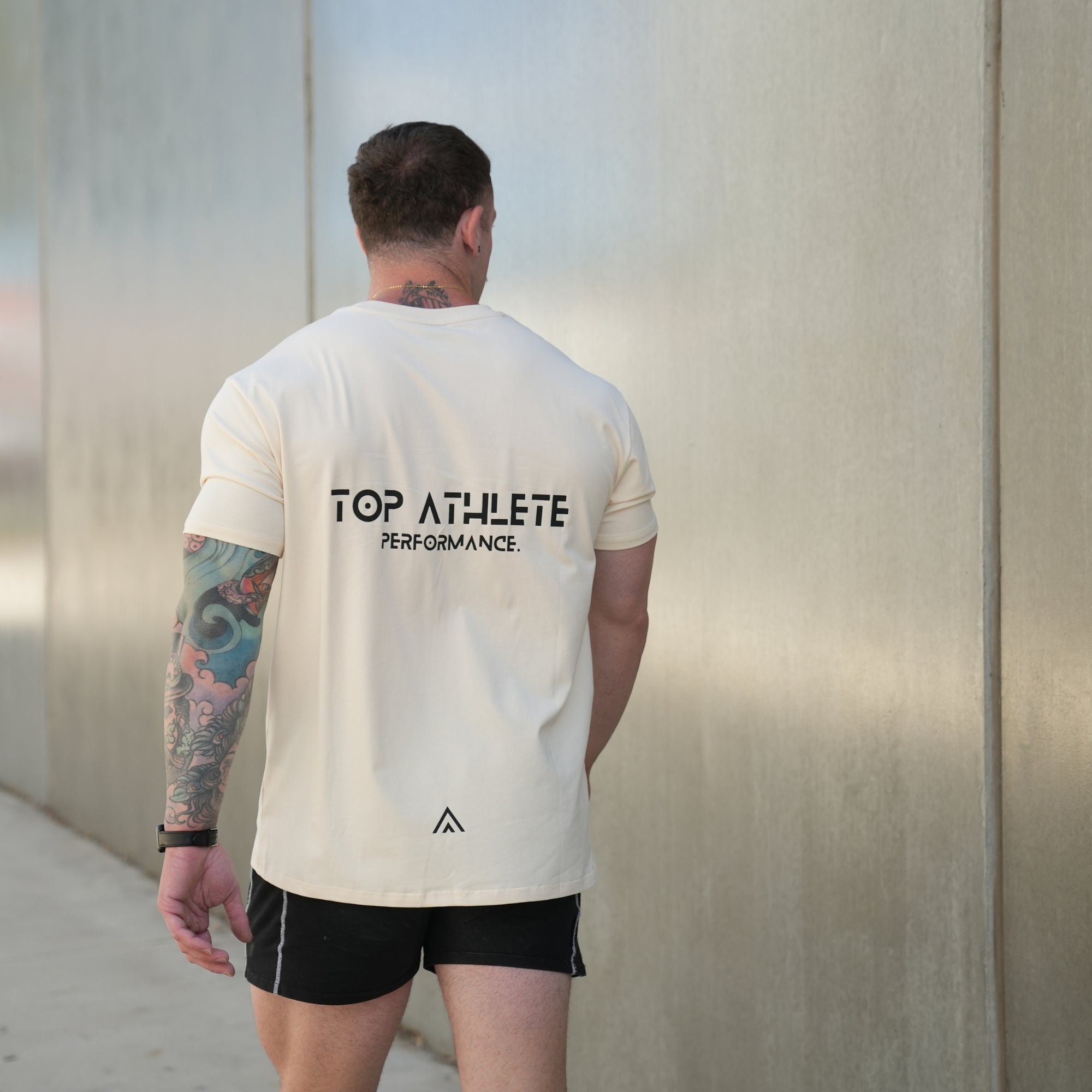 Man wearing a beige top athlete performance tee