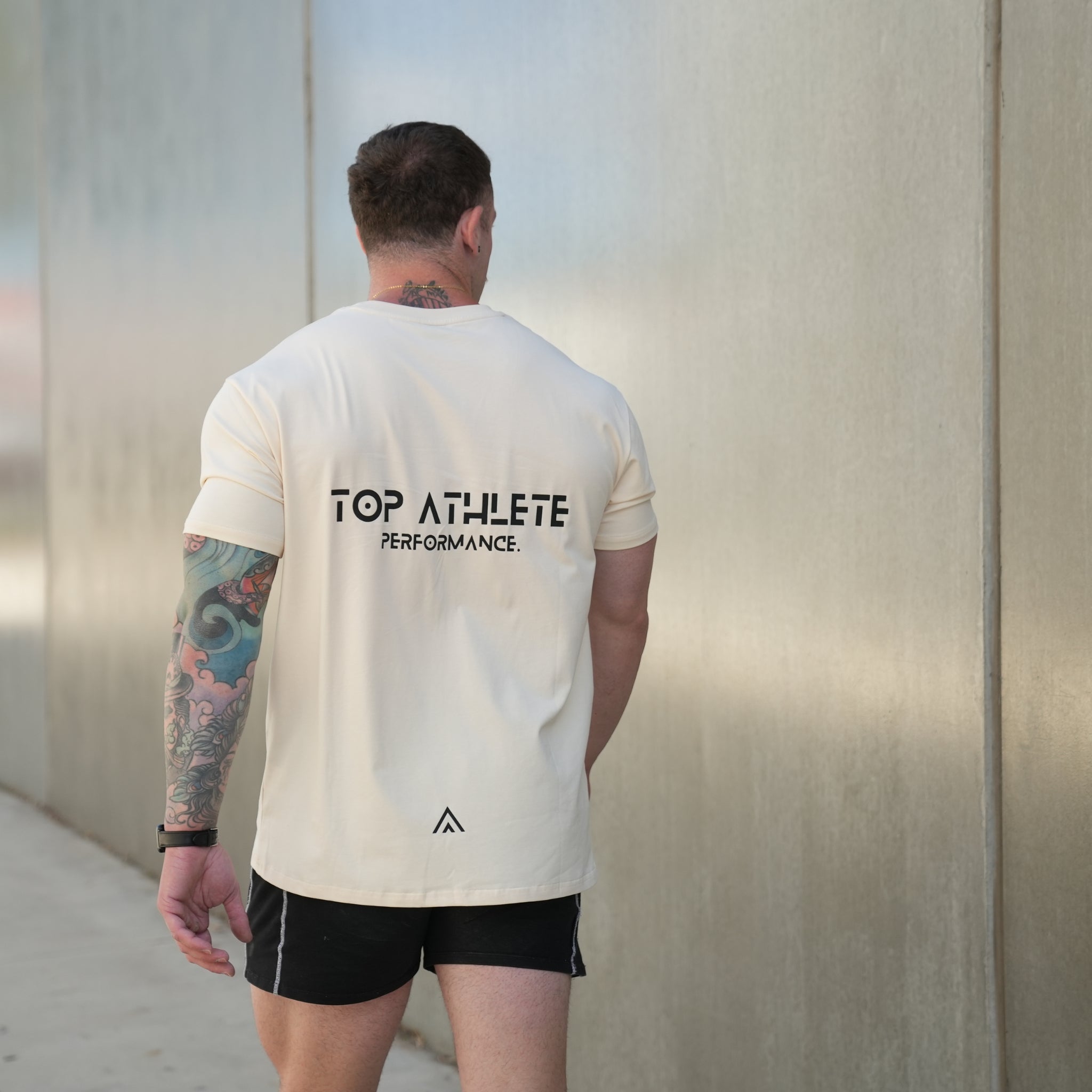 Man wearing a beige top athlete performance tee