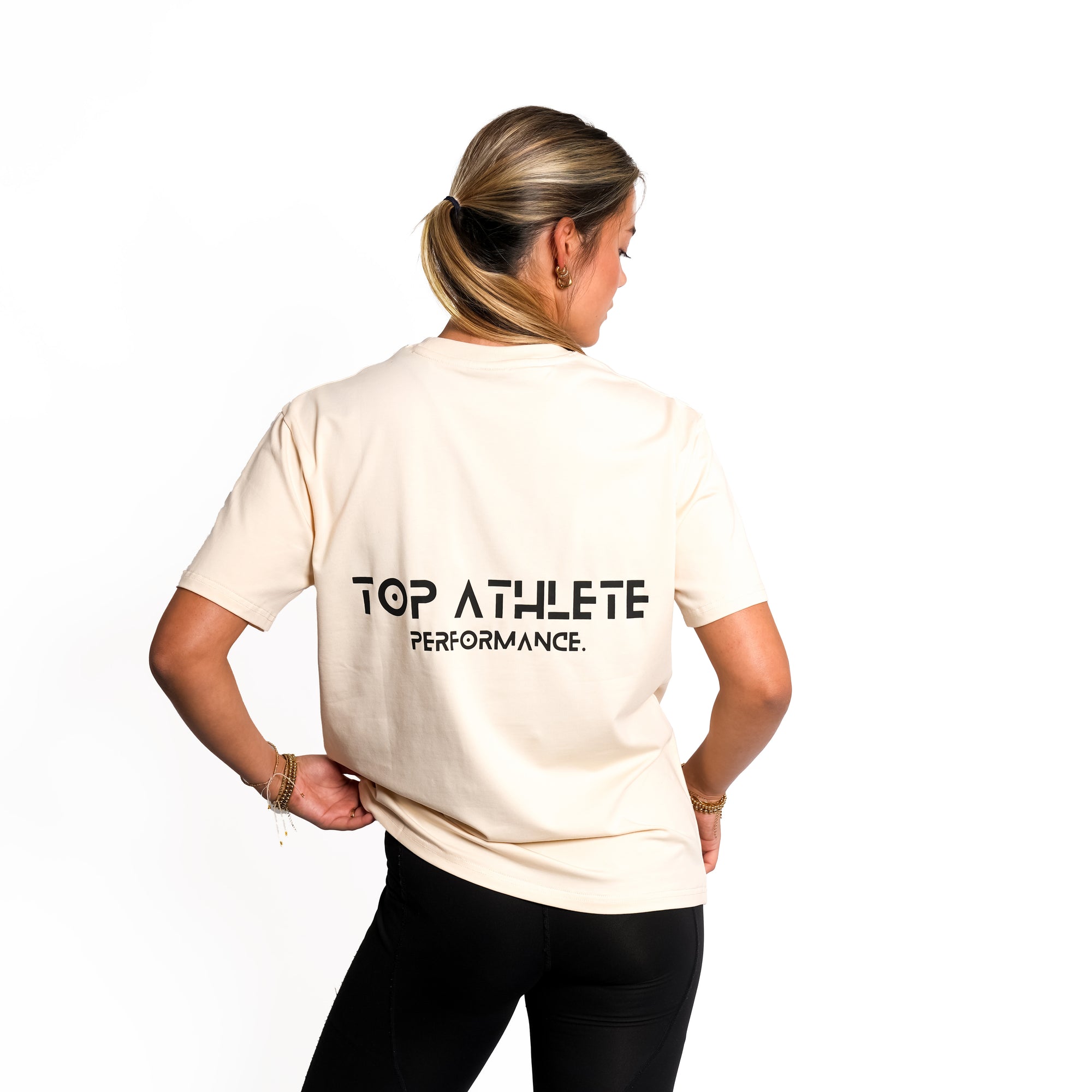 Back view of woman wearing beige colour Top Athlete unisex oversized activewear t-shirt.