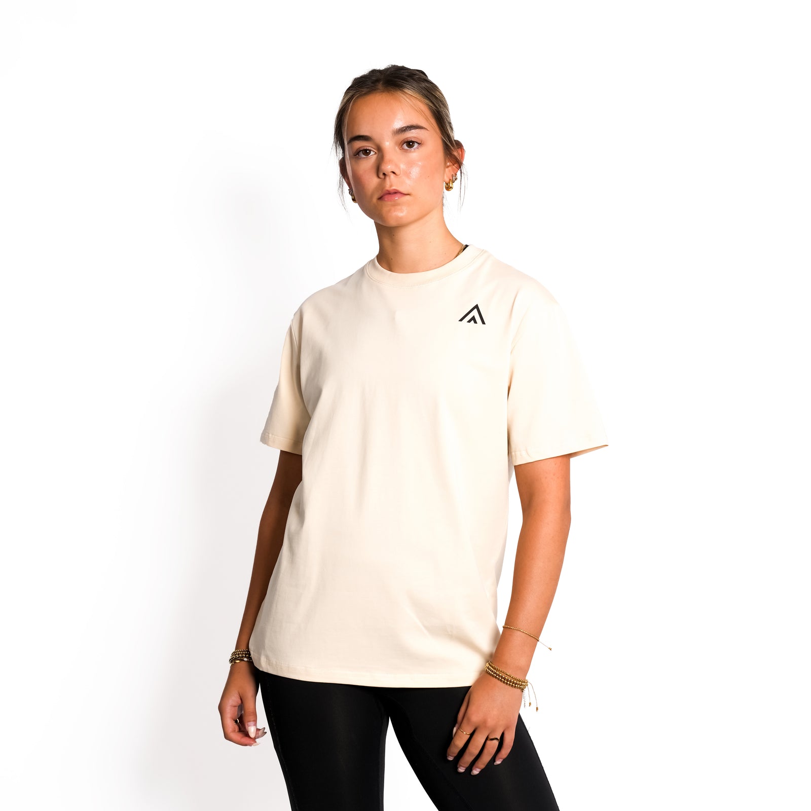 Front view of woman wearing beige colour Top Athlete unisex oversized activewear t-shirt.