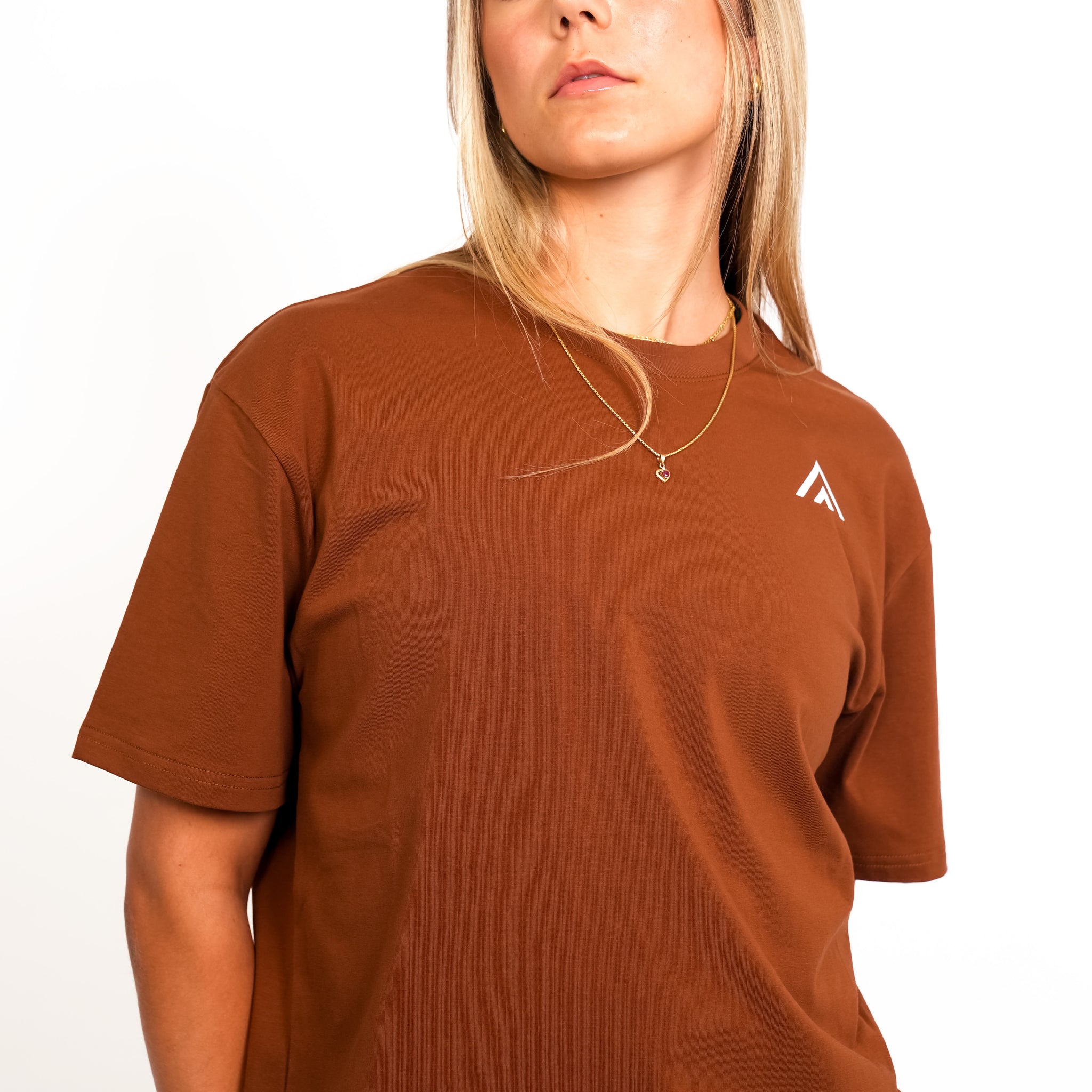 Close up view of woman wearing bronze colour Top Athlete unisex oversized activewear t-shirt.